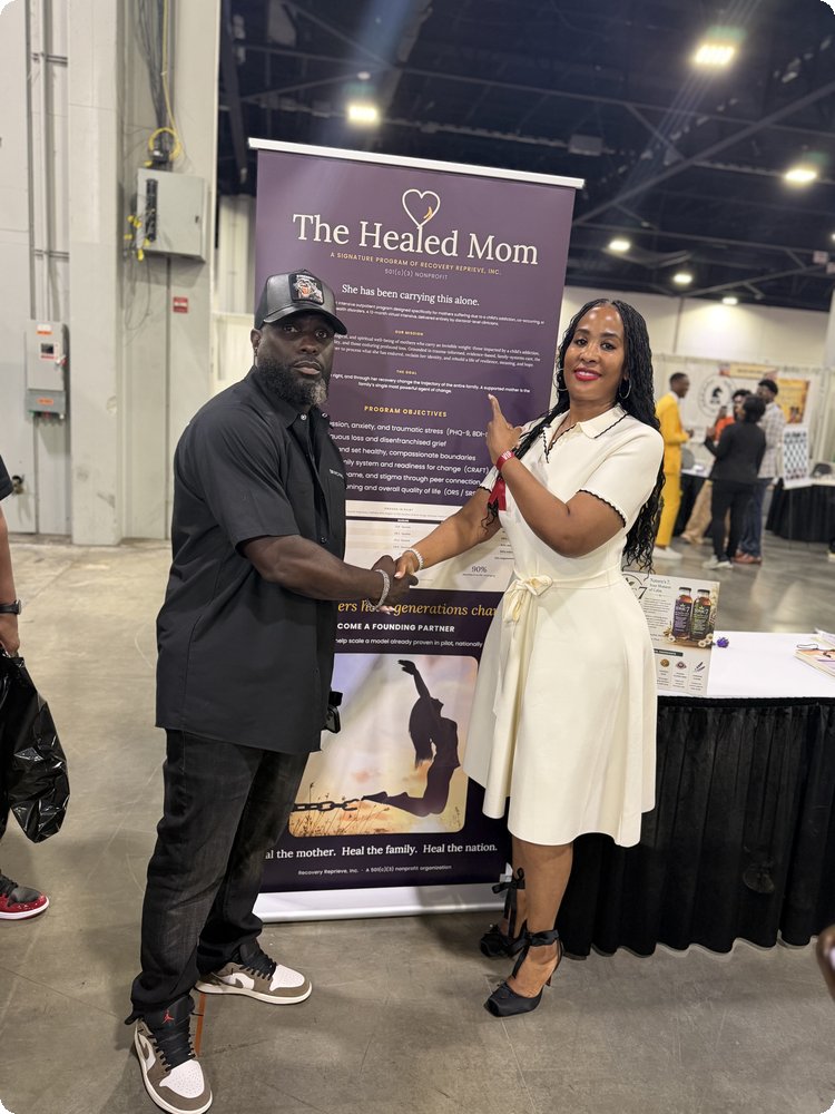 Dr. Scherri Culp shaking hands with a guest in front of The Healed Mom banner