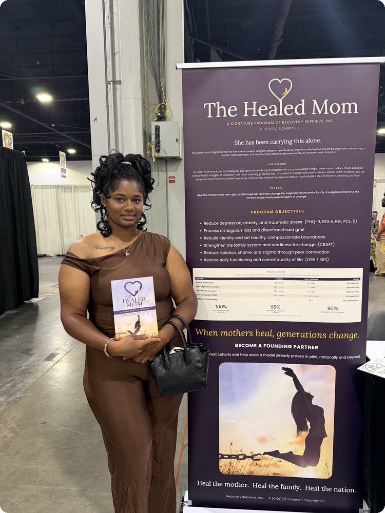 A guest at the InvestFest booth in front of The Healed Mom banner
